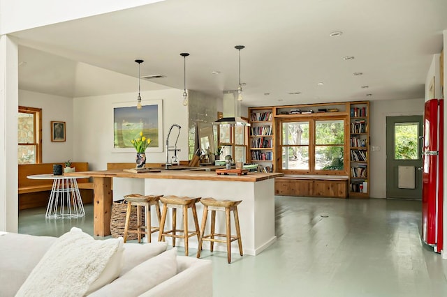 5204 Cueva Dr, Austin, TX 78738 - kitchen with open floor plan, island exhaust hood, wood counters, and finished concrete flooring