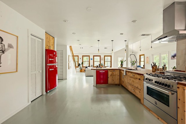5204 Cueva Dr, Austin, TX 78738 - kitchen featuring high end range, wall chimney range hood, open floor plan, recessed lighting, and light brown cabinets