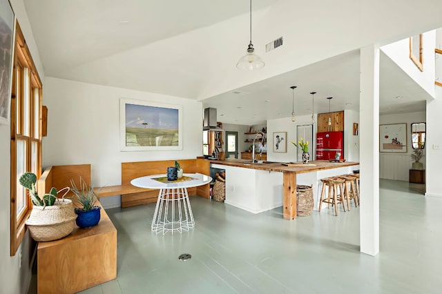 5204 Cueva Dr, Austin, TX 78738 - kitchen featuring concrete flooring, wall chimney range hood, decorative light fixtures, and lofted ceiling