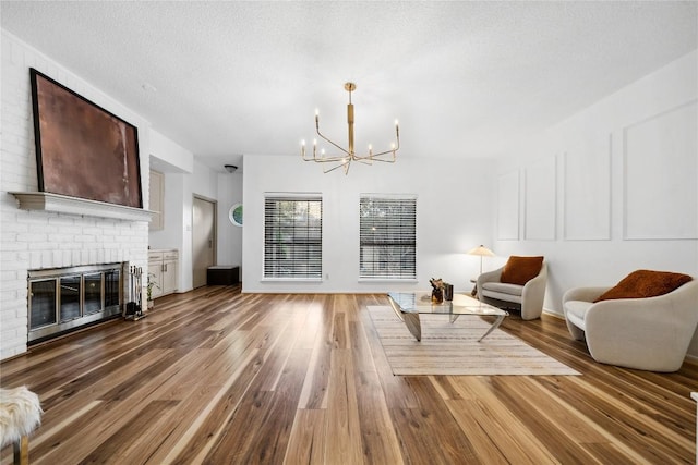 7162 Chimney Cors Unit 7204, Austin, TX 78731 - living area with a chandelier, wood finished floors, a fireplace, and a textured ceiling
