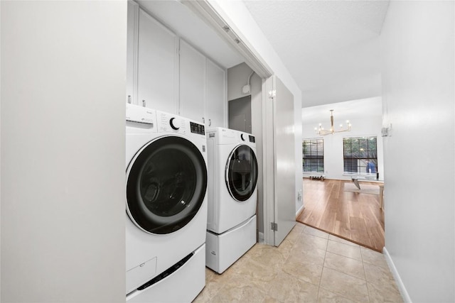 7162 Chimney Cors Unit 7204, Austin, TX 78731 - laundry room with washing machine and clothes dryer, a chandelier, cabinet space, and light tile patterned flooring