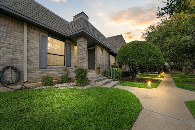 7162 Chimney Cors Unit 7204, Austin, TX 78731 - view of front facade featuring roof with shingles, brick siding, and a front yard