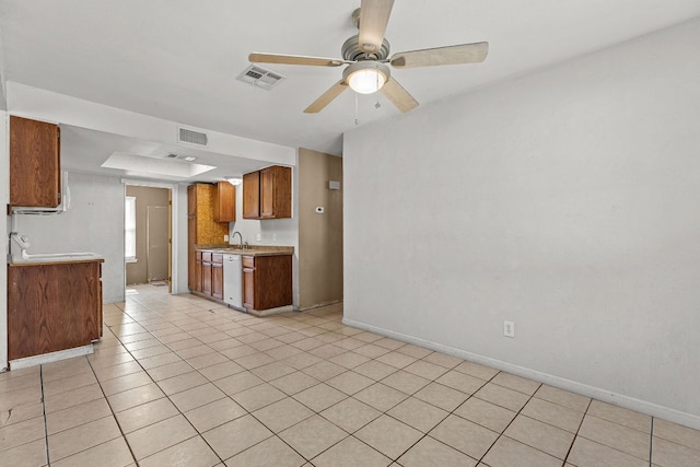 1703 Greyson Dr, Round Rock, TX 78664 - kitchen with dishwasher, light countertops, a ceiling fan, brown cabinets, and light tile patterned flooring