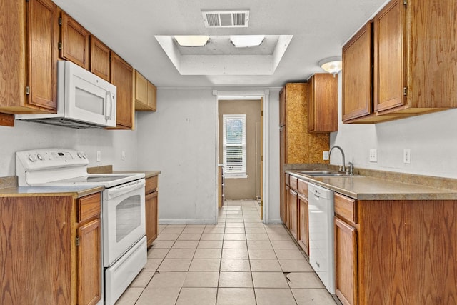 1703 Greyson Dr, Round Rock, TX 78664 - kitchen featuring white appliances, brown cabinetry, a raised ceiling, and light tile patterned floors