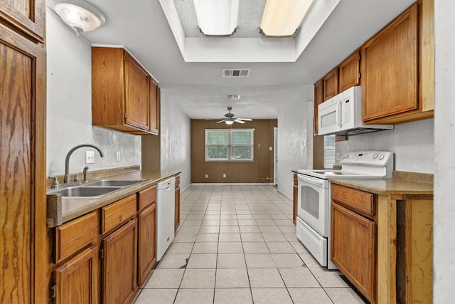 1703 Greyson Dr, Round Rock, TX 78664 - kitchen with white appliances, brown cabinetry, light tile patterned floors, and ceiling fan