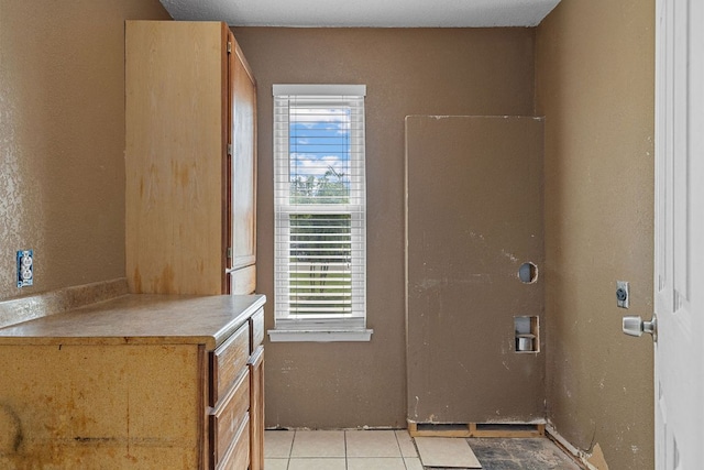 1703 Greyson Dr, Round Rock, TX 78664 - laundry room with hookup for an electric dryer, healthy amount of natural light, light tile patterned floors, and washer hookup