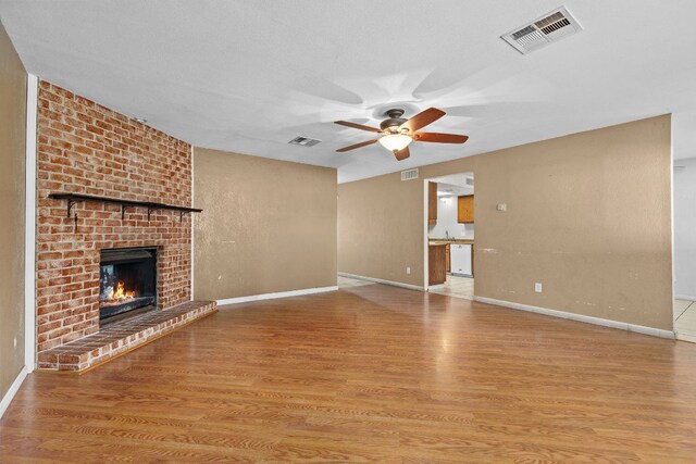 1703 Greyson Dr, Round Rock, TX 78664 - unfurnished living room featuring ceiling fan, wood finished floors, and a fireplace