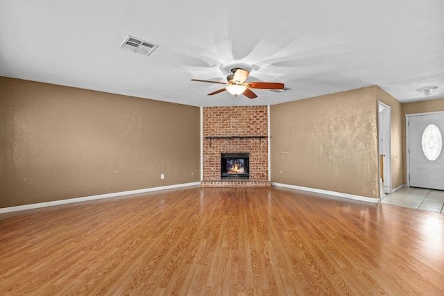 1703 Greyson Dr, Round Rock, TX 78664 - unfurnished living room with ceiling fan, light wood-type flooring, and a brick fireplace