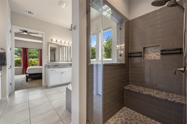 105 Curacao Ct, Austin, TX 78738 - bathroom featuring a tile shower, vanity, ceiling fan, tile patterned floors, and ensuite bath