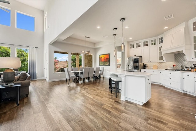 105 Curacao Ct, Austin, TX 78738 - kitchen with stainless steel appliances, open floor plan, a breakfast bar, tasteful backsplash, and a kitchen island with sink