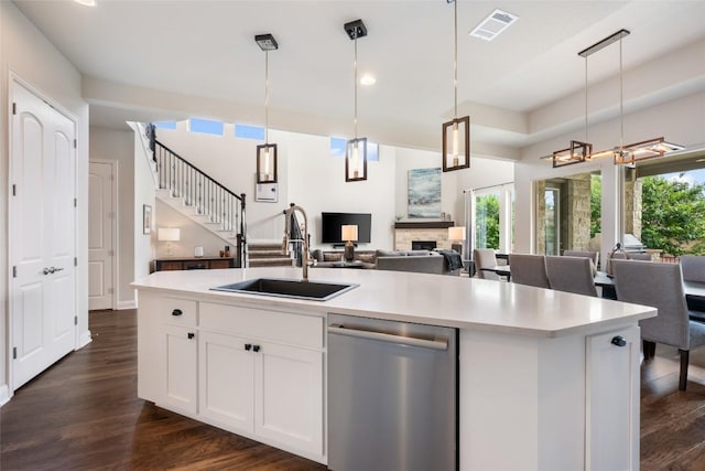 105 Curacao Ct, Austin, TX 78738 - kitchen featuring stainless steel dishwasher, open floor plan, light countertops, dark wood-style floors, and white cabinetry