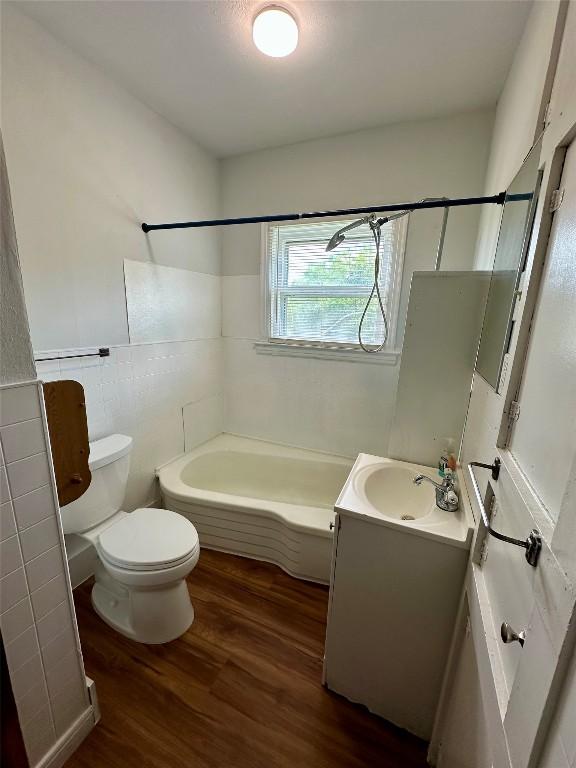 121 Wyers Pl, Cedar Creek, TX 78612 - bathroom featuring vanity, wood finished floors, tile walls, and bathing tub / shower combination