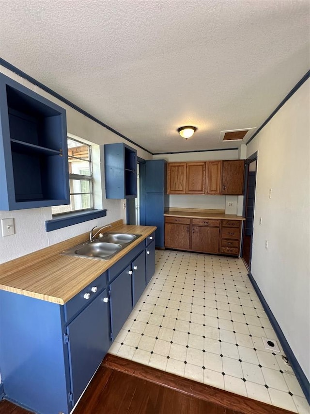 121 Wyers Pl, Cedar Creek, TX 78612 - kitchen featuring open shelves, blue cabinetry, a textured ceiling, light flooring, and light countertops