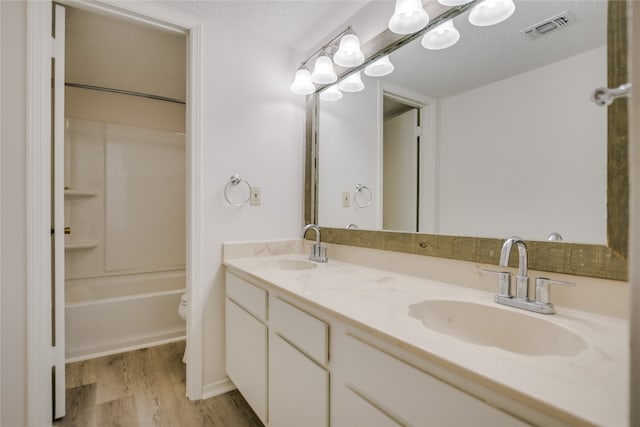 304 Hi There Unit 137, Horseshoe Bay, TX 78657 - full bath featuring wood finished floors, double vanity, bathing tub / shower combination, and a textured ceiling
