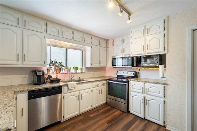 3704 Austin Cv, Lago Vista, TX 78645 - kitchen featuring appliances with stainless steel finishes, tasteful backsplash, dark wood-style flooring, white cabinets, and a textured ceiling
