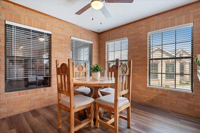 3704 Austin Cv, Lago Vista, TX 78645 - dining room featuring wood finished floors, brick wall, a ceiling fan, and crown molding