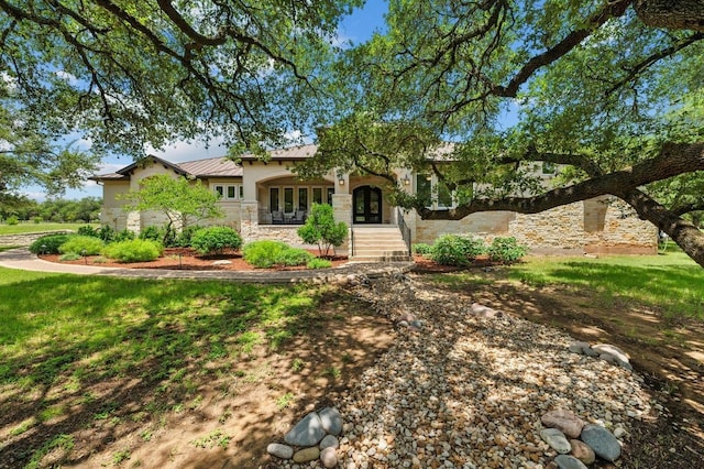 343 Covered Wagon Way, Driftwood, TX 78619 - view of front of home featuring french doors, stone siding, a metal roof, a standing seam roof, and stucco siding