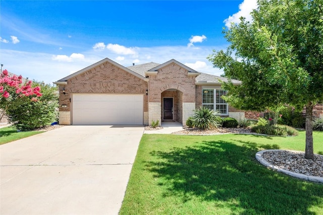 14 Acacia Way, Georgetown, TX 78633 - view of front facade featuring brick siding, an attached garage, driveway, a front lawn, and roof with shingles
