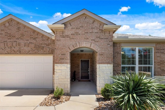 14 Acacia Way, Georgetown, TX 78633 - view of front of property featuring brick siding, an attached garage, driveway, and stone siding
