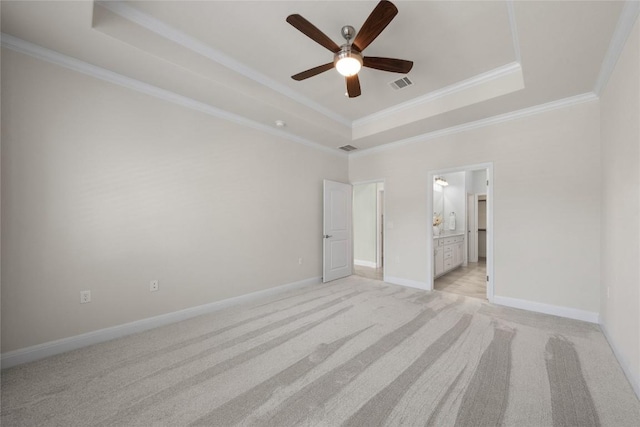 14 Acacia Way, Georgetown, TX 78633 - unfurnished bedroom featuring a tray ceiling, ornamental molding, light colored carpet, ensuite bath, and a ceiling fan