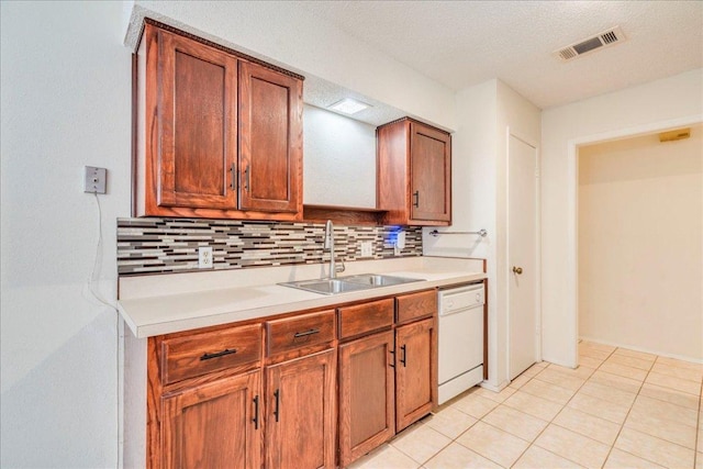 1321 Warrington Dr, Austin, TX 78753 - kitchen with white dishwasher, backsplash, light countertops, and light tile patterned floors