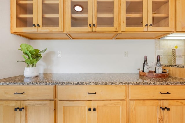 211 E Creek Dr, Dripping Springs, TX 78620 - kitchen featuring light brown cabinetry, tasteful backsplash, glass insert cabinets, and dark stone counters