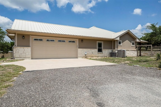 211 E Creek Dr, Dripping Springs, TX 78620 - view of front facade with stone siding, concrete driveway, a garage, and a metal roof