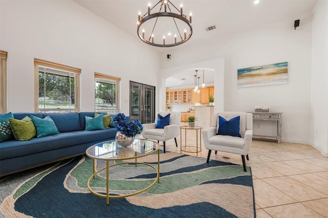 211 E Creek Dr, Dripping Springs, TX 78620 - living area with a chandelier, a towering ceiling, light tile patterned floors, and arched walkways