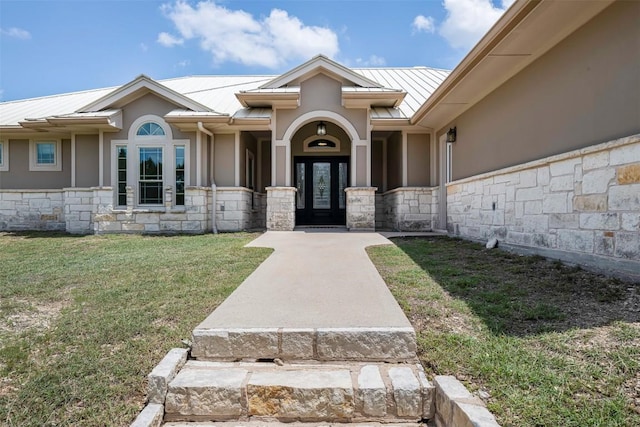 211 E Creek Dr, Dripping Springs, TX 78620 - property entrance featuring stone siding, a standing seam roof, a metal roof, stucco siding, and a lawn
