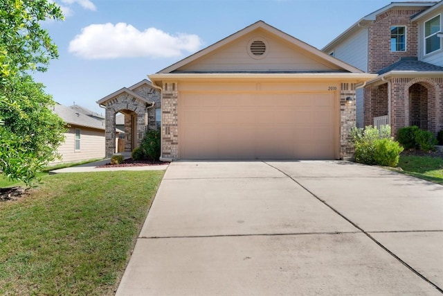 2010 Grow Ln, Austin, TX 78754 - traditional-style house featuring driveway, a garage, a front yard, stone siding, and brick siding