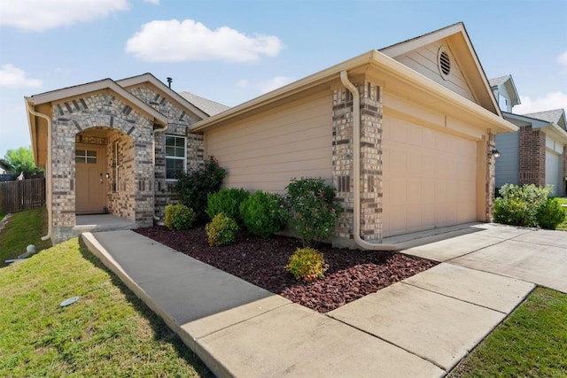 2010 Grow Ln, Austin, TX 78754 - view of front of property featuring an attached garage, driveway, and stone siding