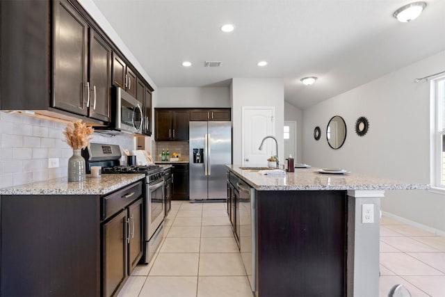 2010 Grow Ln, Austin, TX 78754 - kitchen featuring stainless steel appliances, dark brown cabinets, decorative backsplash, light tile patterned floors, and light stone countertops