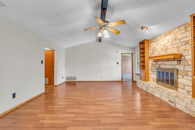 209 Lenz St, Round Rock, TX 78681 - unfurnished living room featuring lofted ceiling, ceiling fan, light wood-style flooring, a fireplace, and a textured ceiling
