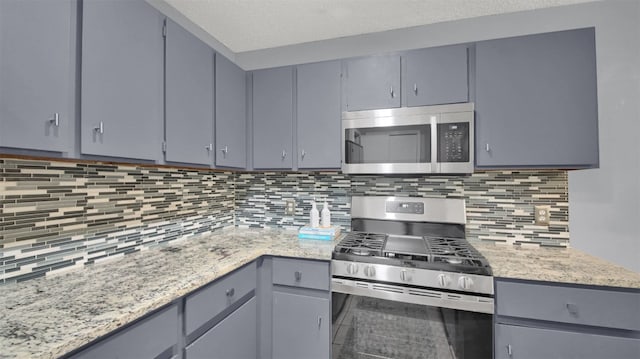 12307 Emery Oaks Rd, Austin, TX 78758 - kitchen featuring stainless steel appliances, gray cabinets, and backsplash