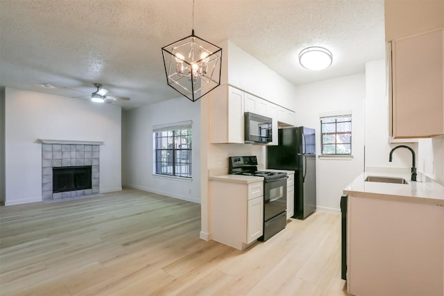 203 E 31st St Unit 206, Austin, TX 78705 - kitchen featuring black appliances, a textured ceiling, a ceiling fan, light countertops, and light wood-style floors