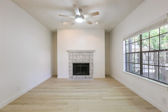 203 E 31st St Unit 206, Austin, TX 78705 - unfurnished living room with wood finished floors, a ceiling fan, a fireplace, and a textured ceiling