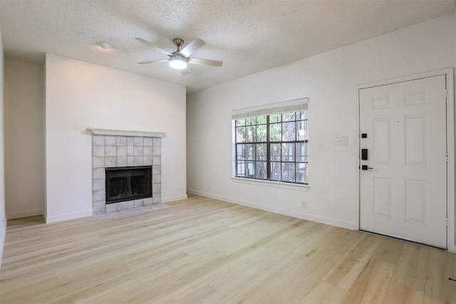 203 E 31st St Unit 206, Austin, TX 78705 - unfurnished living room with a ceiling fan, wood finished floors, a fireplace, and a textured ceiling