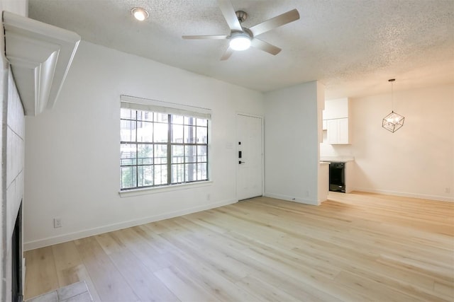 203 E 31st St Unit 206, Austin, TX 78705 - unfurnished living room featuring a textured ceiling, a ceiling fan, light wood-type flooring, and a fireplace
