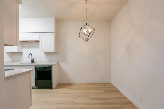 203 E 31st St Unit 206, Austin, TX 78705 - kitchen with black dishwasher, light countertops, white cabinetry, light wood-style floors, and hanging light fixtures