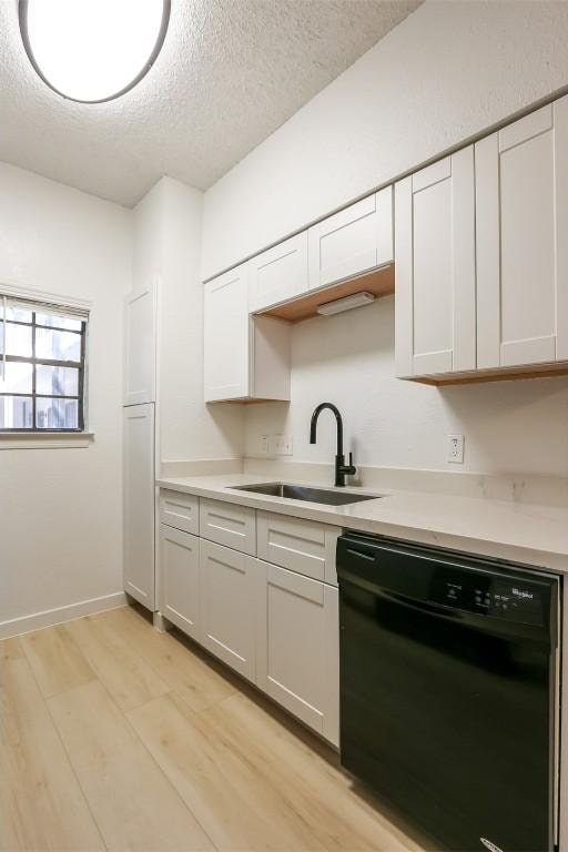203 E 31st St Unit 206, Austin, TX 78705 - kitchen featuring dishwasher, a textured ceiling, light countertops, white cabinets, and light wood finished floors