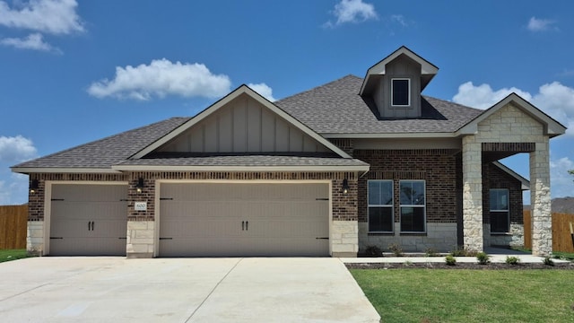 600 Sydney Blvd, Thorndale, TX 76577 - craftsman-style home featuring an attached garage, a shingled roof, board and batten siding, stone siding, and driveway