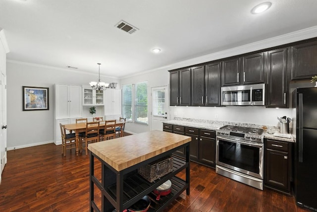 12532 Labrador Cv, Austin, TX 78729 - kitchen featuring appliances with stainless steel finishes, crown molding, a chandelier, dark wood-style floors, and recessed lighting