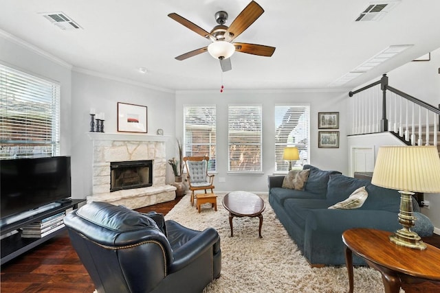 12532 Labrador Cv, Austin, TX 78729 - living room featuring crown molding, a ceiling fan, wood finished floors, a fireplace, and stairway