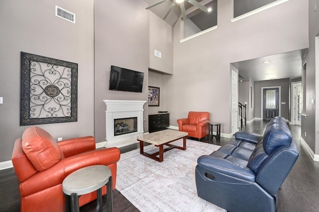 21506 Greylag Dr, Pflugerville, TX 78660 - living room with a ceiling fan, a high ceiling, a glass covered fireplace, and wood finished floors