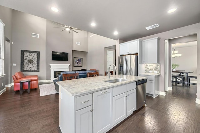 21506 Greylag Dr, Pflugerville, TX 78660 - kitchen featuring appliances with stainless steel finishes, a ceiling fan, dark wood-style floors, a fireplace, and recessed lighting