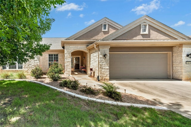 207 Breezeway Ln, Georgetown, TX 78633 - view of front facade featuring stone siding, a garage, driveway, and a shingled roof
