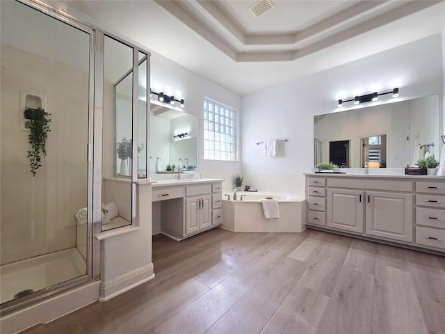 10303 Spicewood Pkwy, Austin, TX 78750 - full bath featuring a garden tub, two vanities, a shower stall, and wood finished floors