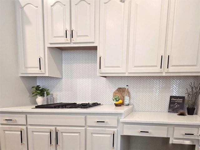 10303 Spicewood Pkwy, Austin, TX 78750 - kitchen with white cabinets, tasteful backsplash, light countertops, and stainless steel gas cooktop