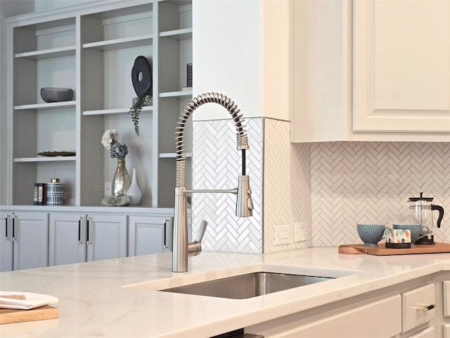 10303 Spicewood Pkwy, Austin, TX 78750 - kitchen featuring decorative backsplash, light stone counters, and white cabinetry