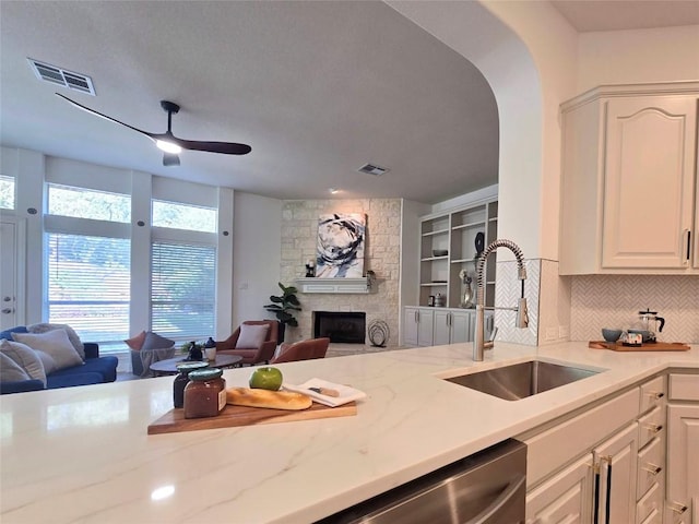 10303 Spicewood Pkwy, Austin, TX 78750 - kitchen with open floor plan, a fireplace, a ceiling fan, and stainless steel dishwasher